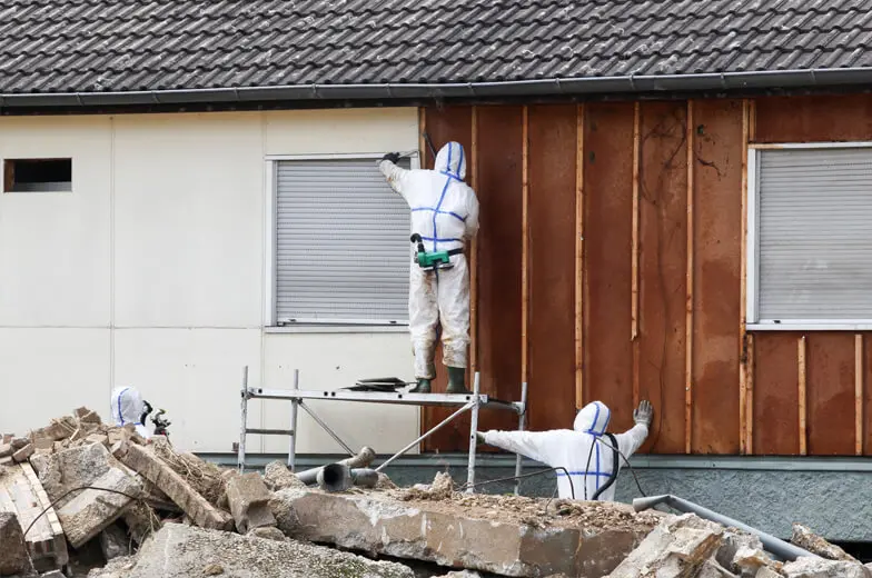 Fachgerechte Untersuchung eines Gebäudes in Schutzkleidung zur Ermittlung möglicher Schadstoffbelastungen in Bauteilen und Innenräumen.