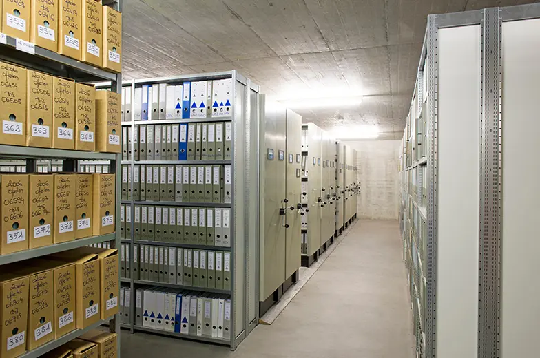 Archivraum mit Regalen, Aktenordnern und Archivkartons zur Untersuchung der Raumluftqualität in Archiven und Aktenlagern.