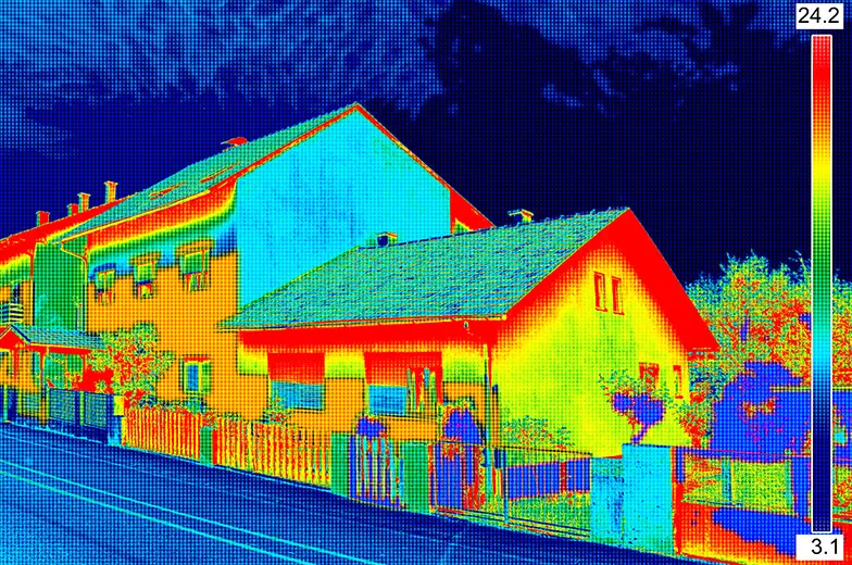 Das Bild zeigt eine Infrarotaufnahme von Häusern. Farbverläufe von blau bis rot zeigen Temperaturunterschiede. Eine Skala rechts gibt Temperaturen von 3,1 bis 24,2 Grad Celsius an.